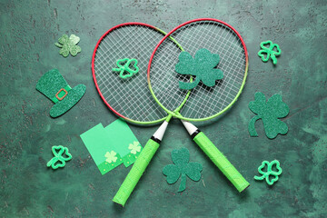 Badminton rackets and decorations for St. Patrick's Day celebration on green grunge background
