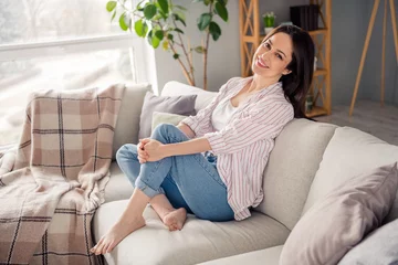  Full length profile photo of adorable satisfied glad person sit barefoot couch free time chill house inside © deagreez