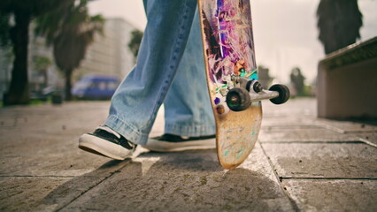 Skateboarder feet standing asphalt with skate board close up. Practicing skating