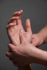 The masseuse massages the client's palms. Close-up of hands at a spa treatment. Vertical photo. 
