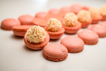 Beige macarons creation, infusing each with creamy