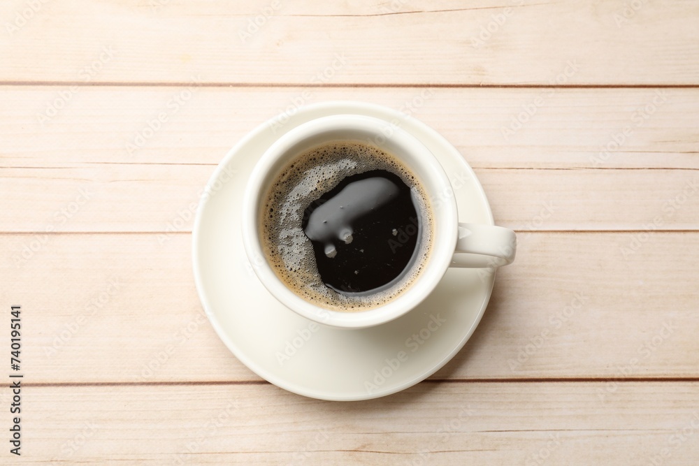 Sticker Cup of aromatic coffee on light wooden table, top view