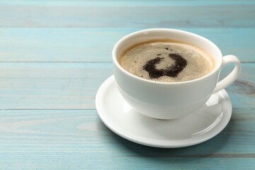 Cup of aromatic coffee on light blue wooden table, closeup. Space for text