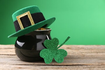 St. Patrick's day. Pot of gold with leprechaun hat and decorative clover leaf on wooden table....