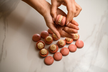 Crafting perfect beige macarons with a creamy filling.