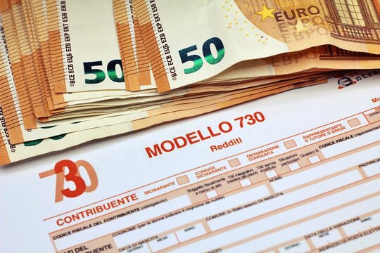 Province of Florence , January 14th 2024, many euro banknotes with the &ldquo;Modello 730&rdquo; as background , translating in Italian as declaration of incomes , concept of tax payment .
