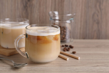 Fresh coffee, beans and straws on wooden table. Space for text