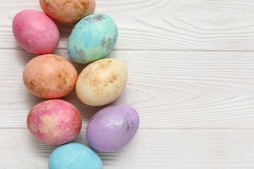 Painted Easter eggs on white wooden background
