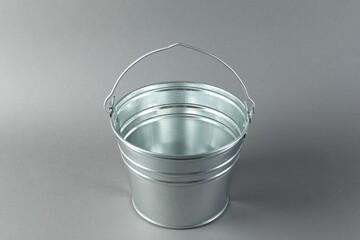One shiny metal bucket on light grey background