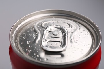 Energy drink in wet can on light grey background, closeup