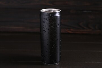 Energy drink in wet can on dark wooden table