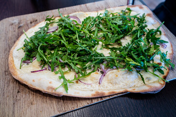 Tarte flambee with Cottage cheese, Roquefort cheese, red onions, rocket salad