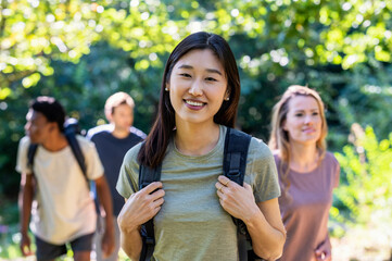 Young adult woman looking at the camera while hiking with friends