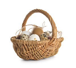 Wicker basket with Easter eggs and feathers on white background