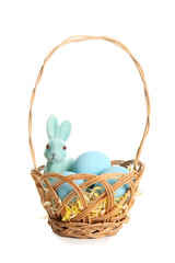 Wicker basket with painted Easter eggs and toy bunny on white background