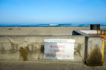 Common sense restrictions warning painted on seawall at Mission Beach in San Diego, California