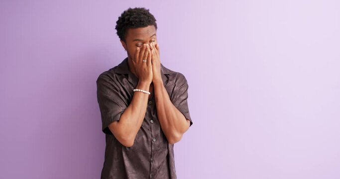 African ashamed tired surprised young man 20s wears black shirt put hand on face facepalm epic fail mistaken omg gesture isolated on violet background studio portrait, guy cannot believe in failure