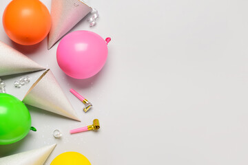 Party hats, balloons, noisemakers and confetti on white background
