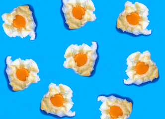 Egg in the cloud on the blue background. Flat lay. Pattern. Top view.