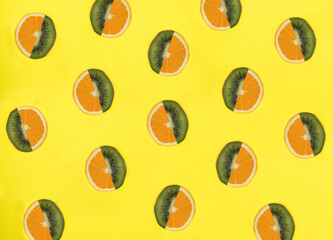Half kiwi and orange on the yellow background. Collage. Flat lay. Top view.