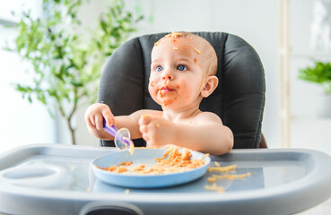 Little baby eating her dinner and making a mess