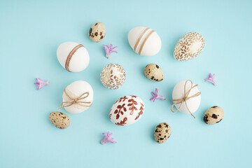 Decorated Easter eggs and purple flowers on blue background