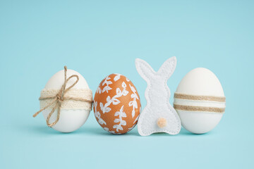 Decorated Easter eggs and fabric bunny on blue background