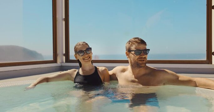 couple relaxing in rooftop jacuzzi bath on sunny day. summer vacation, getaway travel