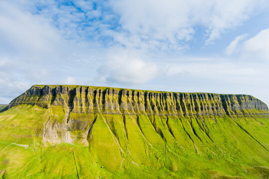 Aerial view of Benbulbin, aka Benbulben or Ben Bulben, iconic landmark, flat-topped nunatak rock formation. Magnificent costal driving route view at Wild Atlantic Way, County Sligo, Ireland.