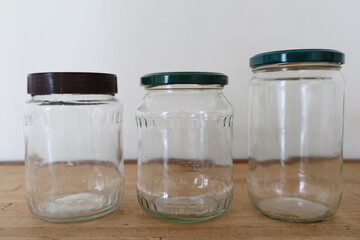 three transparent empty glass jars on wooden counter