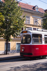 Red European street car in front of historic buildings