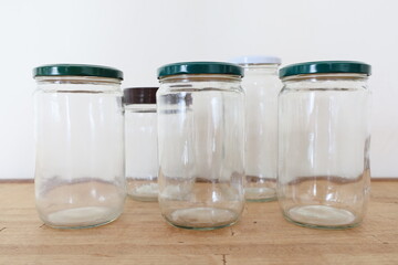 multiple transparent empty glass jars on wooden counter