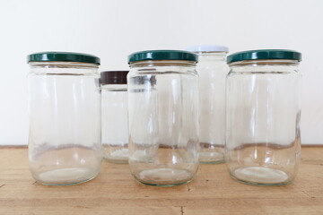 multiple transparent empty glass jars on wooden counter