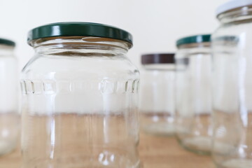 multiple transparent empty glass jars on wooden counter