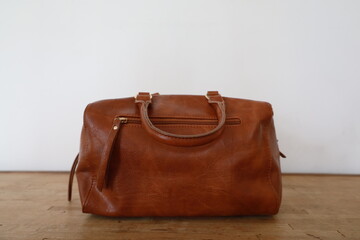 brown leather handbag presentation on minimalist background