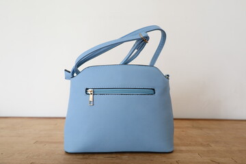 blue leather handbag presentation on minimalist background