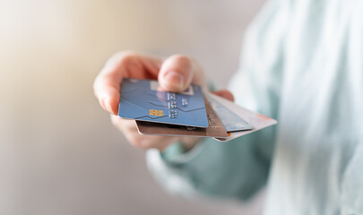 Woman holding credit and debit cards, choosing which to use (all Identifying information removed, altered)