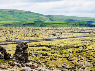 Car driving over old green lava field in Iceland - 740242372