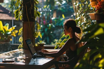 female digital nomad working on laptop home office with green plants. female programmer and  it girl. Professional influencer or blogger, content creator.  - obrazy, fototapety, plakaty
