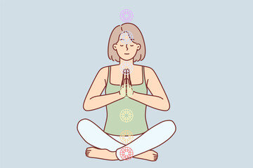Woman practices yoga sitting in lotus position to cleanse aura and activate chakras