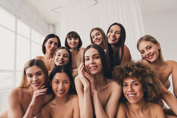 Photo of ten beautiful ladies in beige underwear posing for body positive topic magazine over white studio background