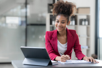 Young businesswoman analyzing graphs on a tablet in a modern office. Data-driven decision-making...