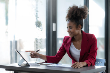 Young businesswoman analyzing graphs on a tablet in a modern office. Data-driven decision-making...