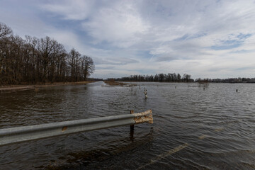flooded road, early spring flood, river overflowing its banks, environmental pollution, ecology