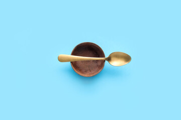 Bowl and spoon on color background