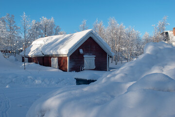 Red cabin photographed in a snowy winter forest in lapland in Sweden