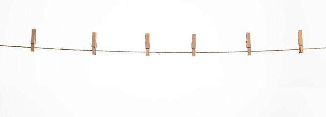 wooden clothespins on a rope on a white background isolate - obrazy, fototapety, plakaty