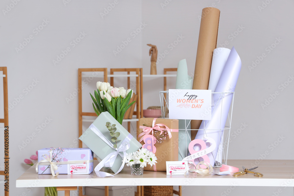 Canvas Prints Beautiful gift boxes, packing materials and flowers for International Women's Day on table against grey wall