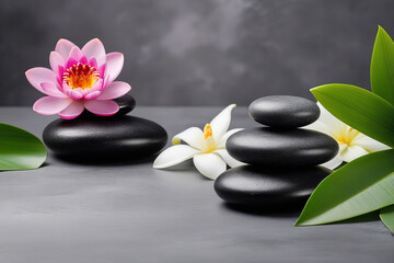 Fototapeta na wymiar Spa gray background with massage stones, exotic flowers and copy space.
