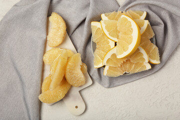 Board and plate with sweet pomelo slices on white background